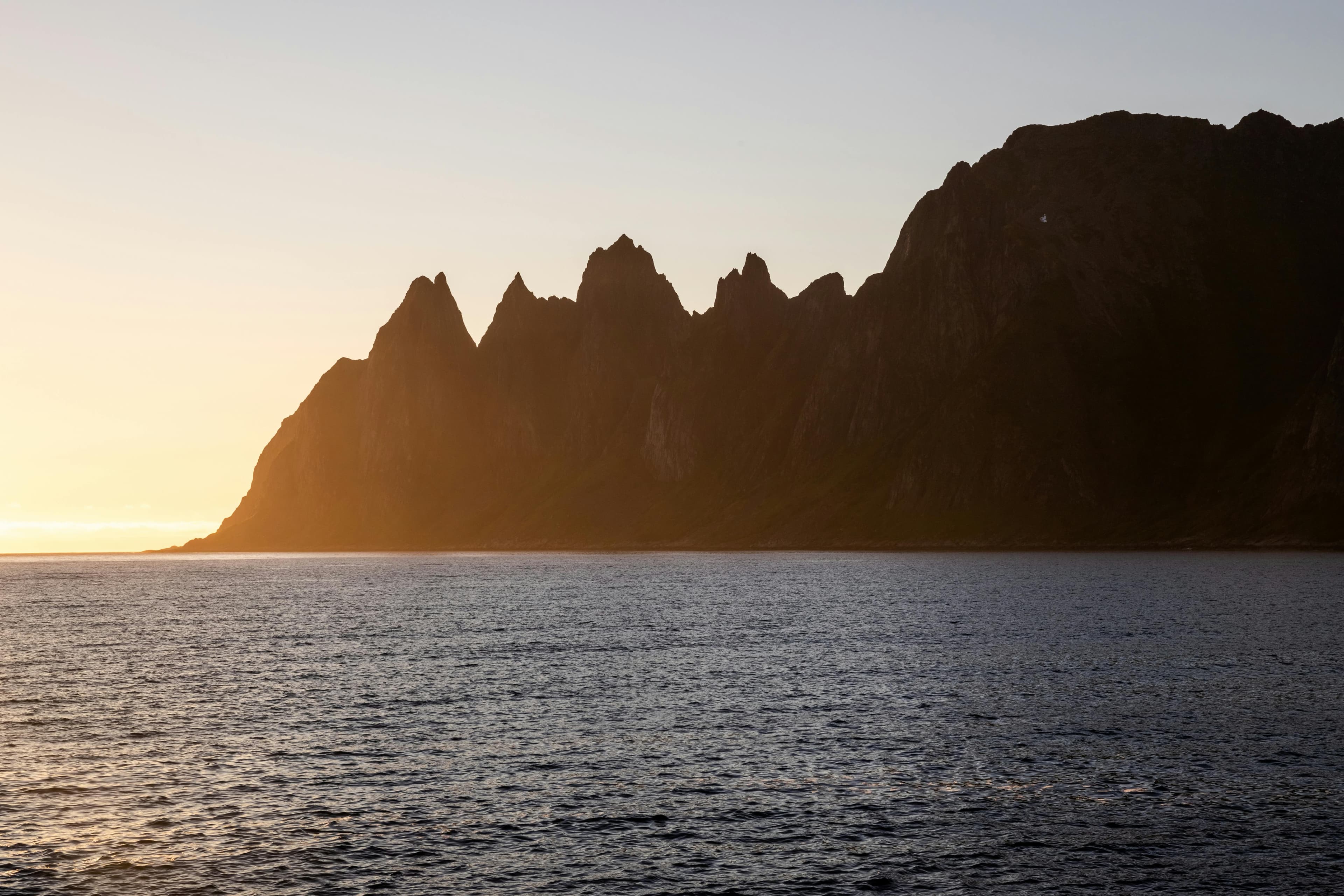 Jagged mountain peaks on Senja rising above the sea